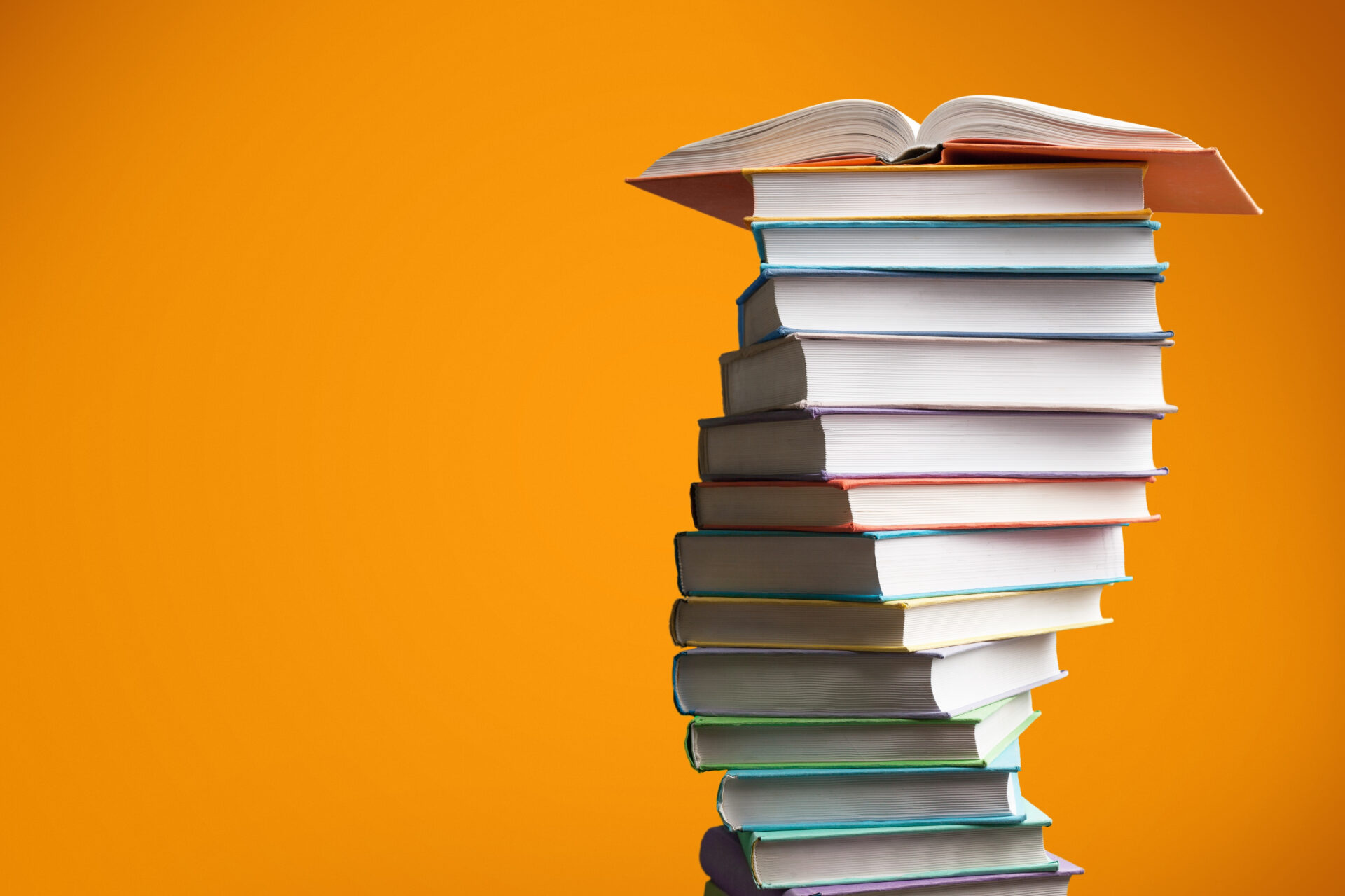 Colorful,Books,Stacking,On,Colored,Background